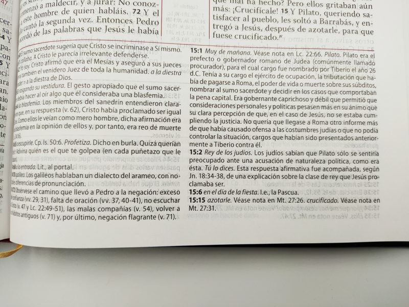 Una imagen muestra páginas abiertas de una Biblia o texto religioso con anotaciones y referencias, enfocando en pasajes específicos y notas al margen.