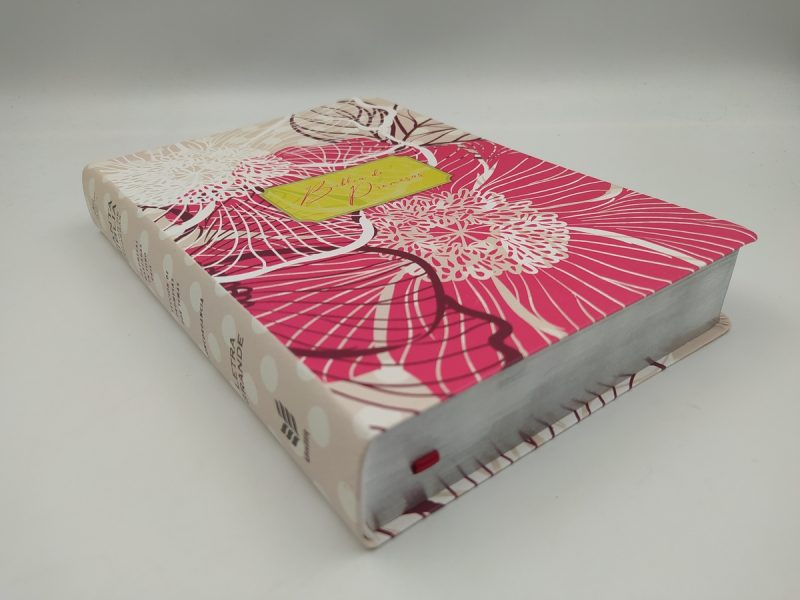 Diario de tapa dura con un diseño floral en tonos rosas y marrones, con detalles en blanco, posado sobre un fondo blanco.