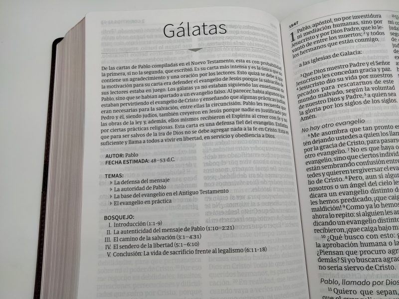 ** Una página abierta de una Biblia mostrando la introducción a la Carta a los Gálatas, incluyendo información sobre el autor, fecha, temas y un bosquejo del contenido.