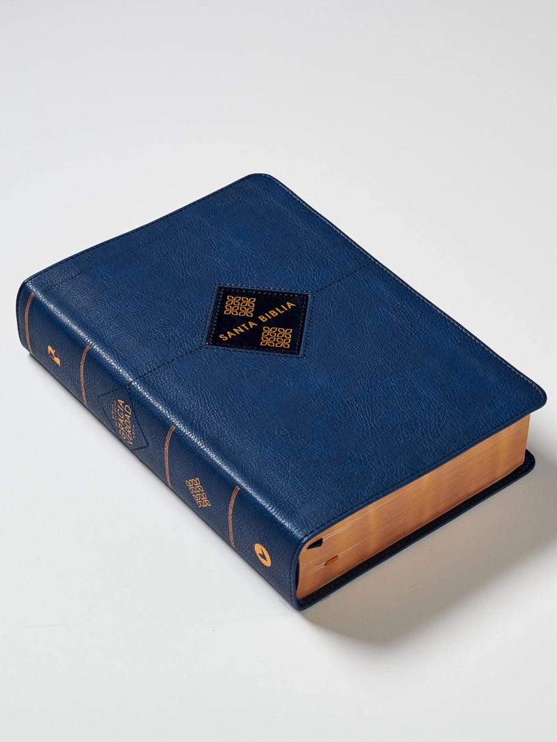 Una Biblia de tapa dura en color azul con detalles dorados en la cubierta y en el lomo, mostrando el texto 'Santa Biblia' y páginas con bordes dorados.