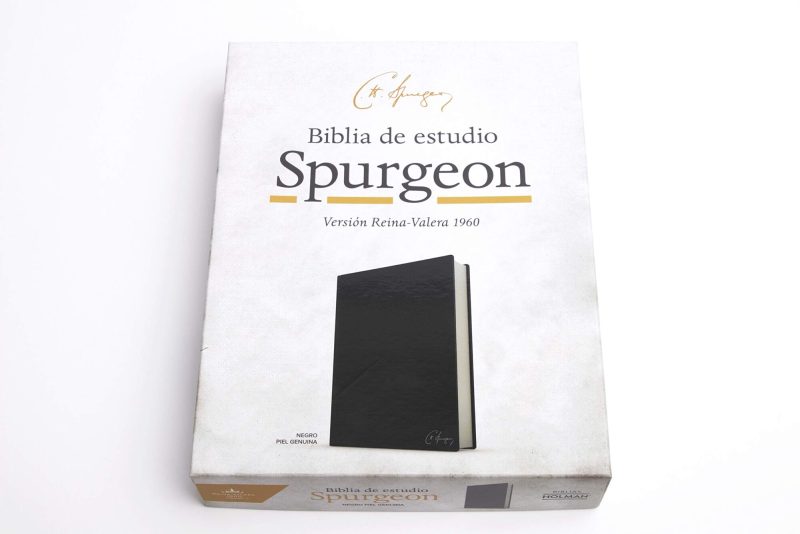 Una Biblia de estudio Spurgeon en versión Reina-Valera de 1960 con tapa de piel genuina negra, apoyada sobre su caja con la imagen y el título en la portada.