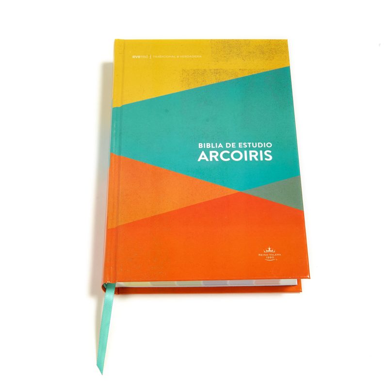 Una Biblia de Estudio Arcoíris con una cubierta colorida en tonos de amarillo, naranja, verde y azul reposando sobre un fondo blanco.