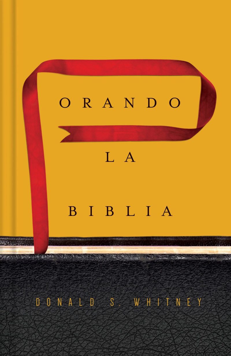 La imagen muestra la portada de un libro titulado Orando La Biblia de Donald S. Whitney. En el fondo hay un color sólido amarillo mostaza, y en primer plano, un marcador de libro rojo se enrosca creando un borde que enmarca el título del libro. El nombre del autor está escrito en la parte inferior sobre una superficie que sugiere ser la cubierta de cuero texturizado de un libro. El diseño es simple pero evocador, posiblemente representando una experiencia personal y contemplativa con la lectura de las escrituras.
