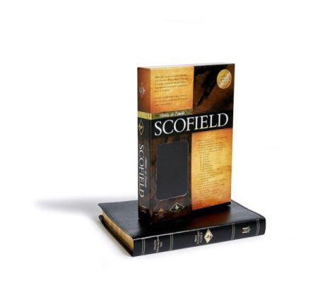 Una Biblia de Estudio Scofield apoyada sobre otra, ambas con cubiertas en tonos negros y dorados, sobre un fondo blanco.