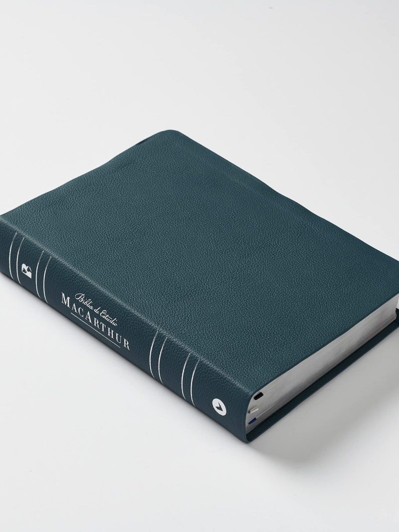 Un libro encuadernado en piel de color verde en posición inclinada sobre un fondo blanco, con el texto 'John F. MacArthur' grabado en dorado en el lomo.