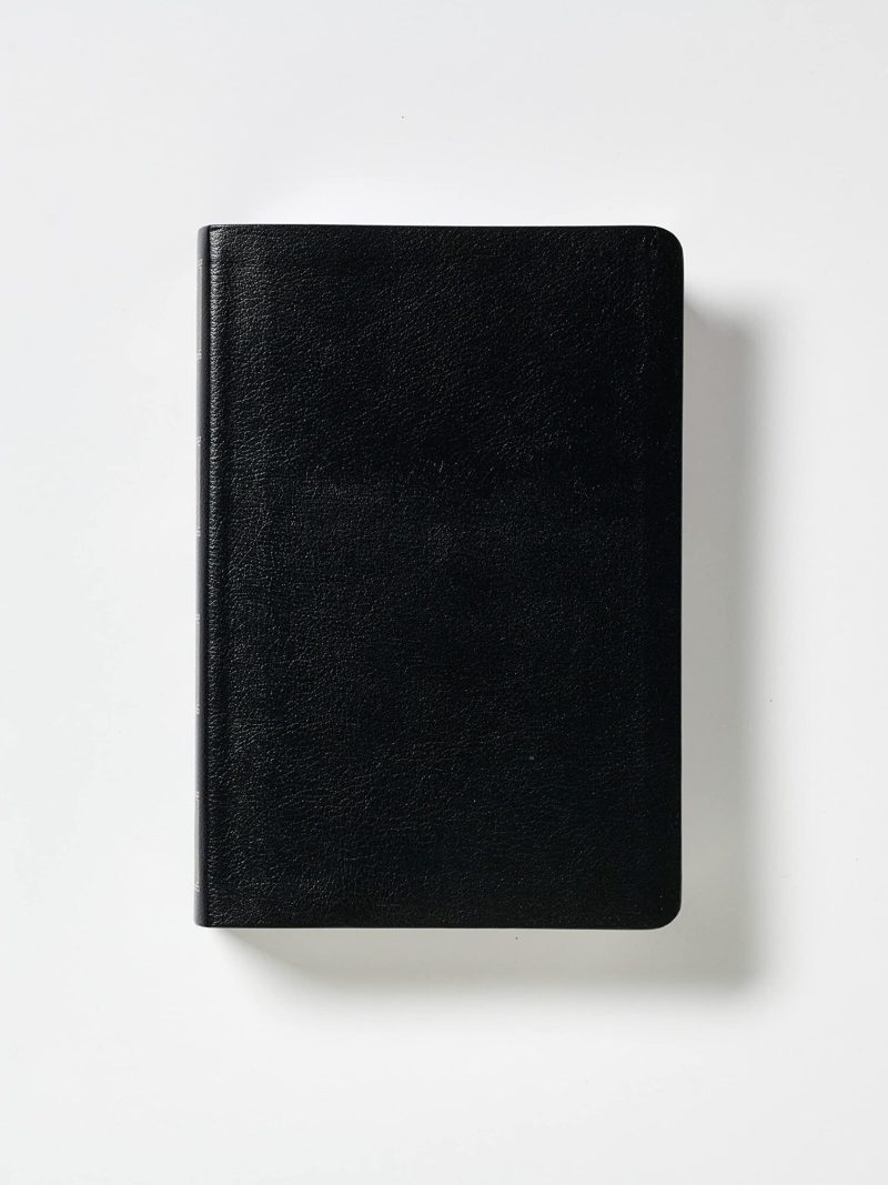 Un cuaderno negro con tapa dura cerrado, sobre un fondo blanco.