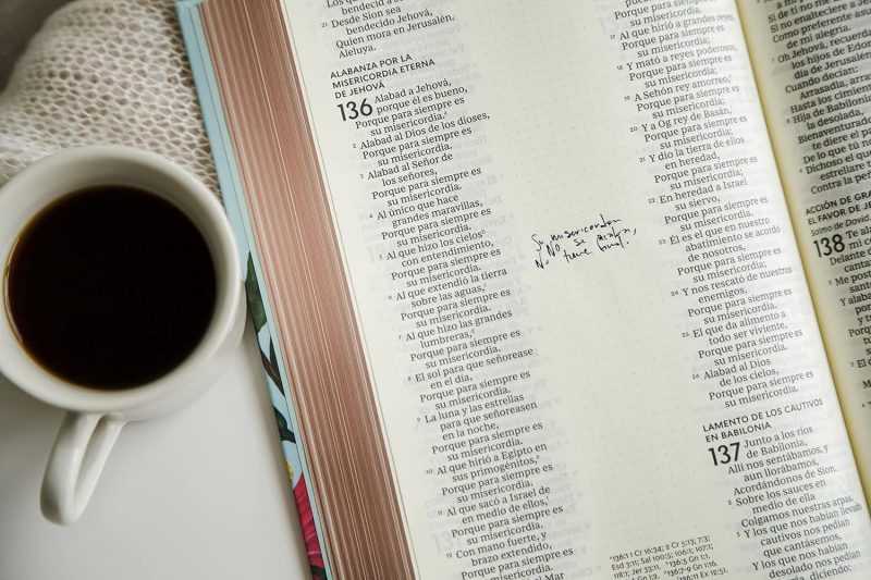 ** Taza de café al lado de un libro abierto con anotaciones en las páginas.