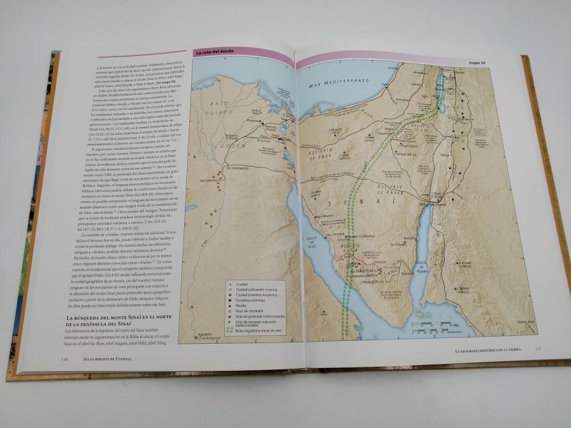 Libro abierto mostrando un mapa que detalla la ruta del Éxodo en la Biblia, con textos explicativos y referencias geográficas relacionadas.