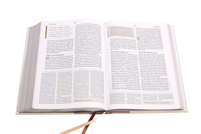 ** Un libro antiguo abierto mostrando texto en dos columnas, con cintas marcadoras visibles en la parte inferior.