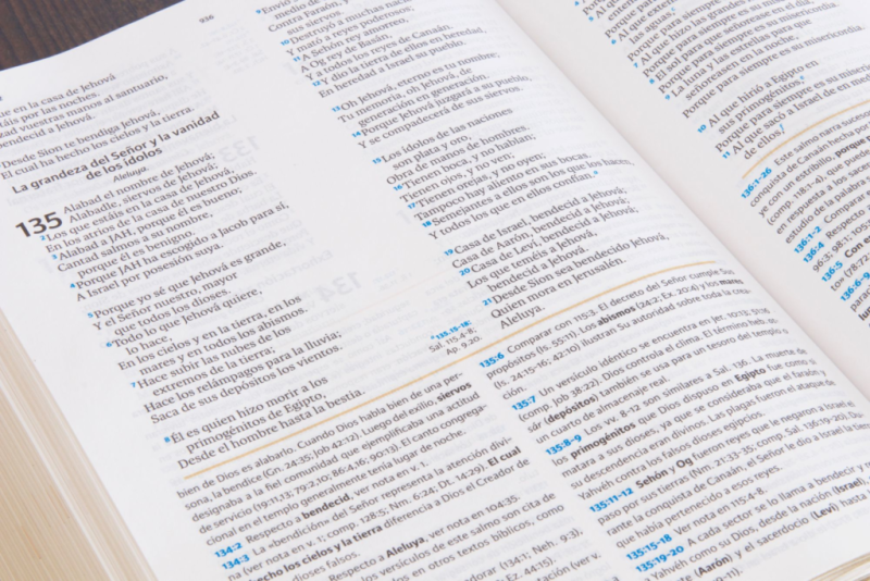 ** Página de un libro abierto mostrando texto en columnas con versículos numerados.