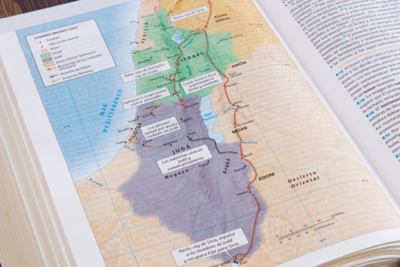 ** Imagen de un libro abierto, mostrando un mapa a color que representa regiones históricas de Israel y Judea.