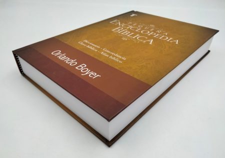 Una Enciclopedia Bíblica cerrada reposando sobre una superficie blanca con el nombre de Orlando Boyer visible en la cubierta.