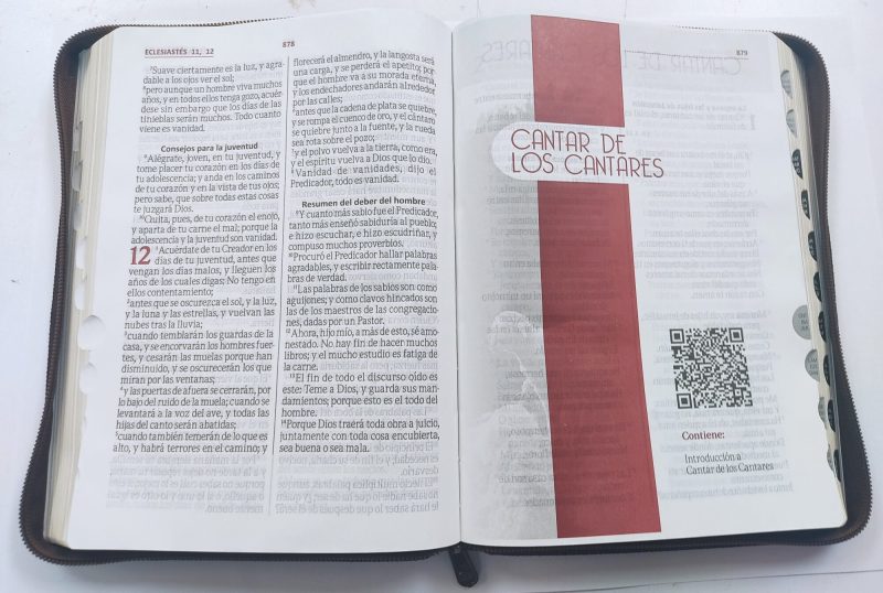 Una Biblia abierta mostrando las páginas del libro del Eclesiastés y una sección titulada 'Cantar de los Cantares', con un marcador de página y un código QR visible.