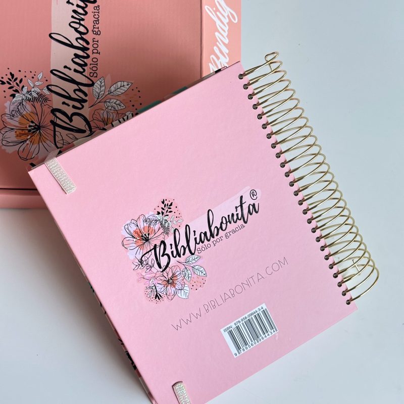 ** Cuaderno de notas rosado con espiral dorado y diseño floral de Biblibonita, junto a una caja del mismo color.
