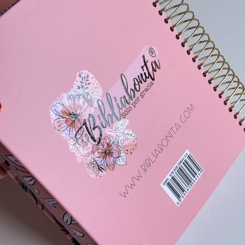 ** Cuaderno en espiral con portada rosa decorada con ilustraciones florales y el logo de Biblibonita.