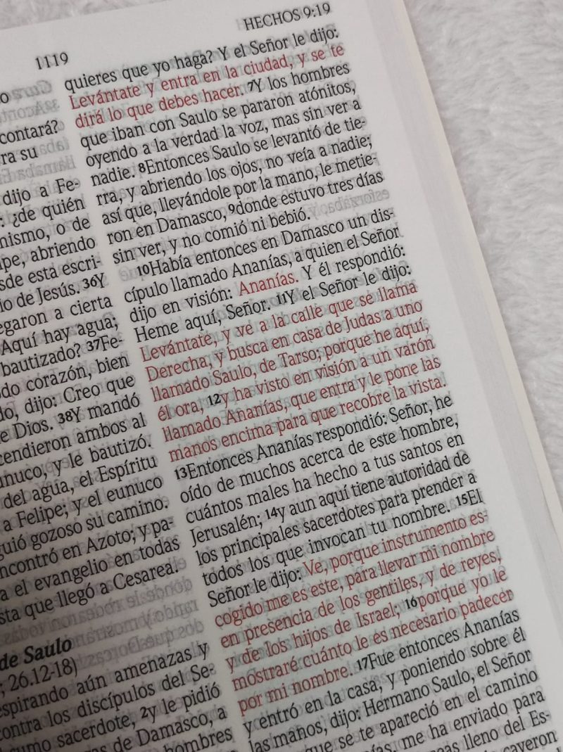 Primer plano de una página de la Biblia con pasajes en español del libro de Hechos, capítulo 9, versículos 11 al 17.
