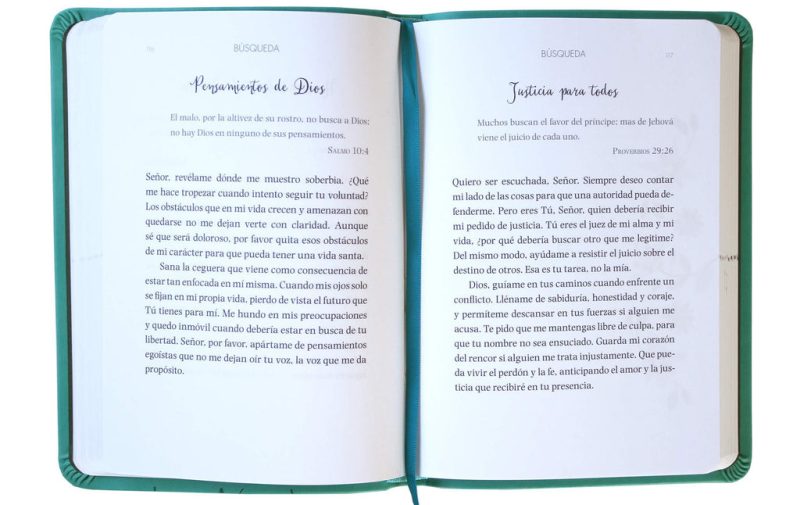 Fotografía de un libro abierto mostrando dos páginas con textos inspiradores y citas bíblicas en español sobre fondo blanco.