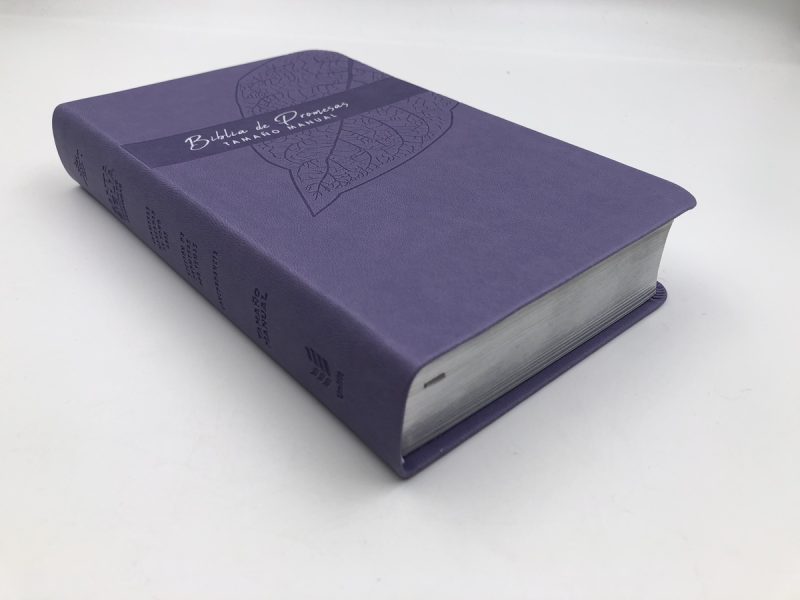 ** Una Biblia de Promesas con cubierta de color morado y detalles en relieve.