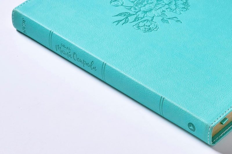 ** Agenda azul con grabado de flores en la tapa y detalles decorativos.
