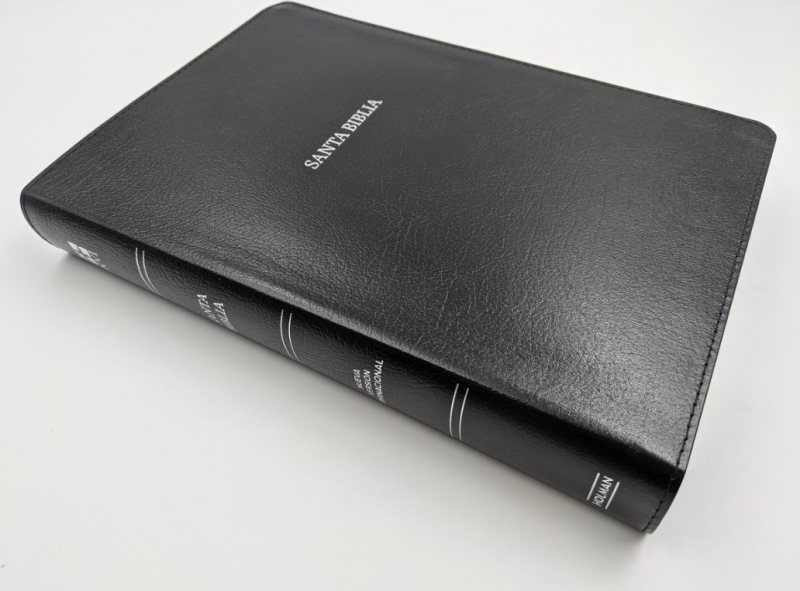 ** Una Biblia de tapa dura negra con el título "Santa Biblia" en la portada.