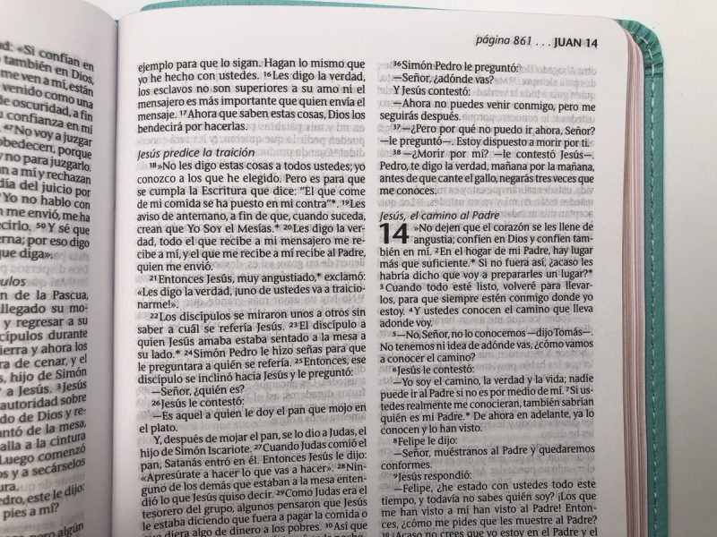 ** Página de una Biblia pequeña en español, abierta en los capítulos 13 y 14 del Evangelio de Juan.