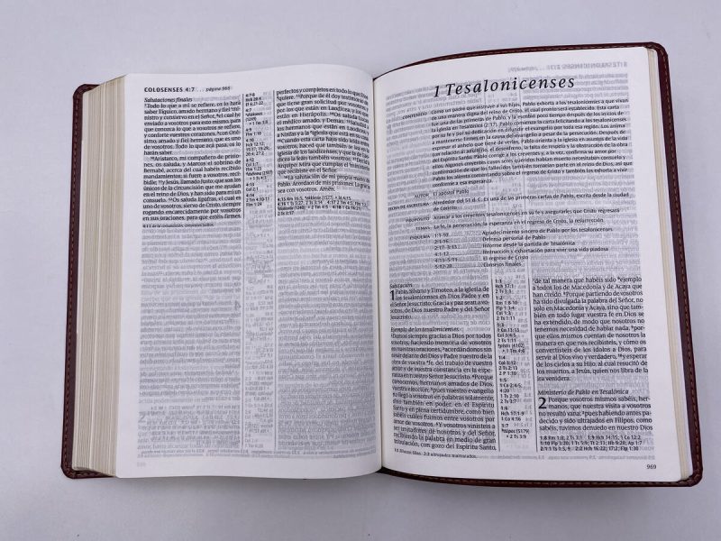 ** Una Biblia abierta mostrando la página del libro de 1 Tesalonicenses en el Nuevo Testamento.