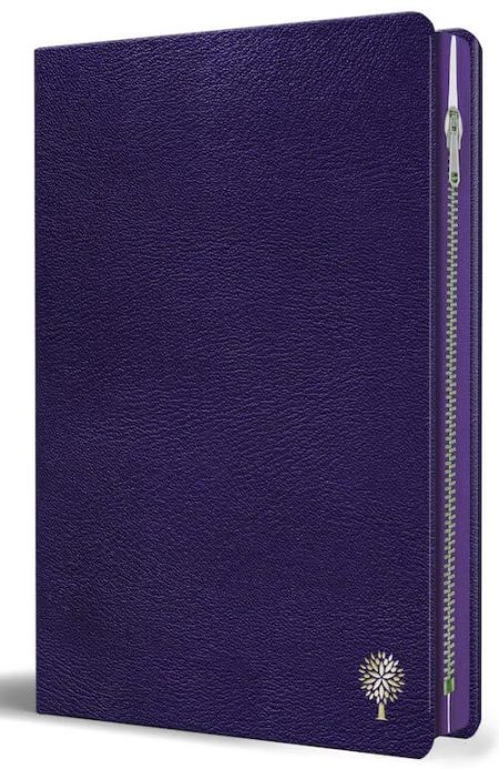 ** Agenda de color morado con textura de cuero y cierre de cremallera, decorada con un pequeño emblema de árbol en la esquina inferior derecha.