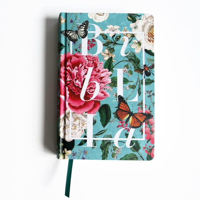 ** Biblia con cubierta floral y mariposas sobre fondo blanco