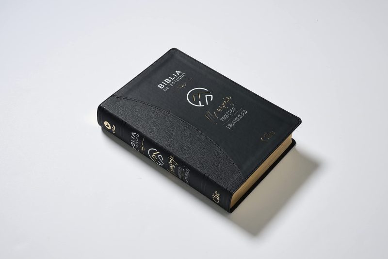 ** Imagen de una Biblia de estudio con cubierta negra y detalles dorados, colocada sobre una superficie blanca.