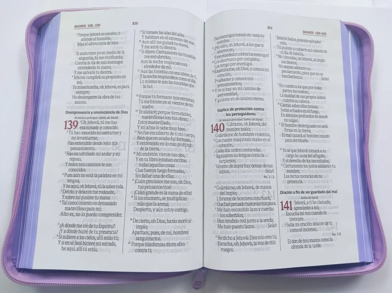 ** Biblia abierta mostrando los Salmos 139, 140 y 141, con una funda protectora de color morado.