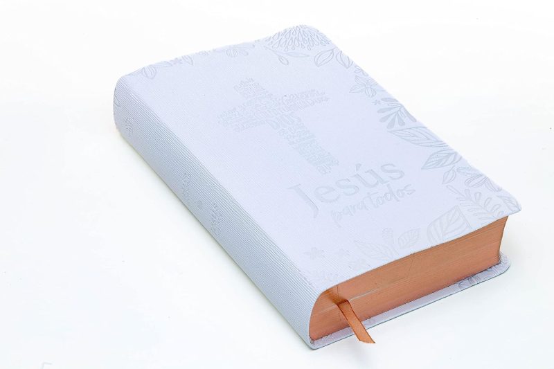 ** Una Biblia de color claro, con una cruz en la cubierta y bordes de las páginas en tono dorado, junto a un marcador de tela naranja.