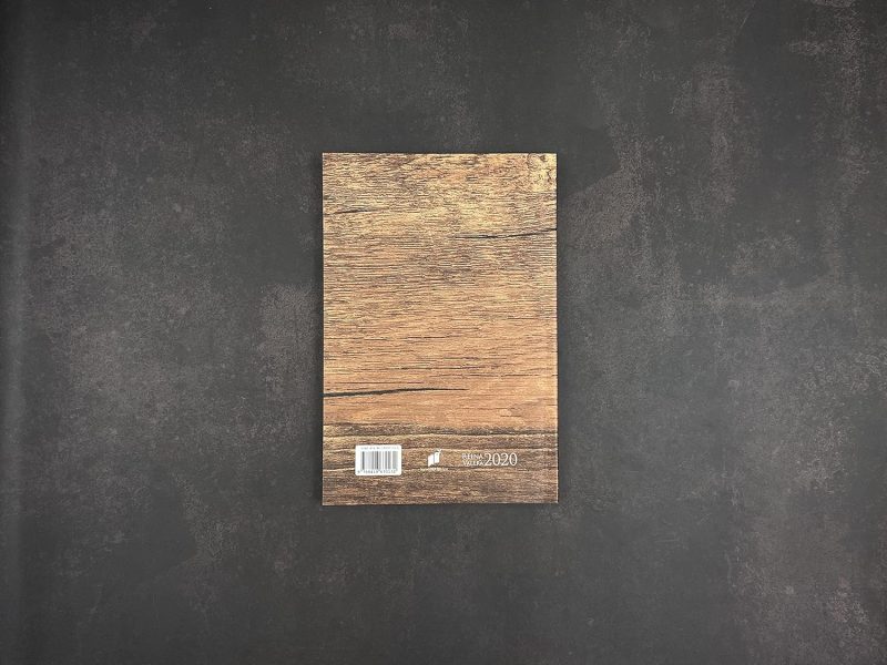 ** Vista trasera de un cuaderno con diseño de madera sobre fondo oscuro.
