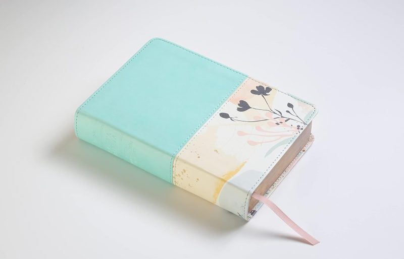 ** Un diario con cubierta de colores pastel y un diseño floral, con un marcador de página rosa.