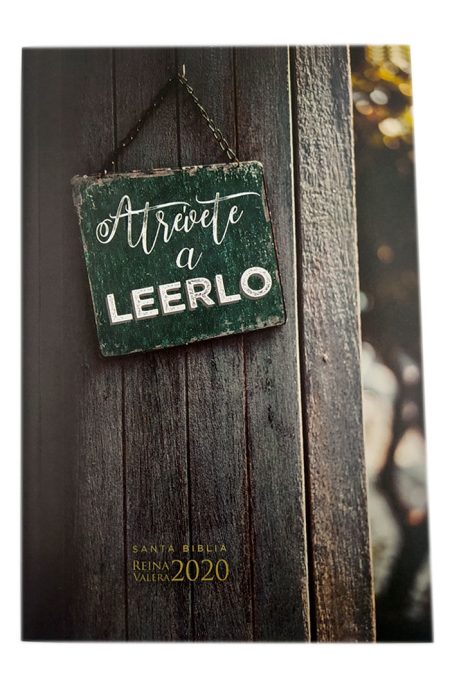 ** Una portada de libro con un letrero colgante que dice "Atrévete a Leerlo" sobre una pared de madera.