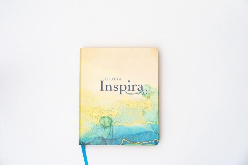 ** Portada de la Biblia Inspira con diseño de acuarela en tonos amarillos y azules.