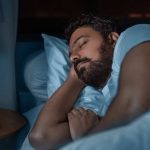 Hombre durmiendo tranquilamente en su cama, con la Biblia a su lado.