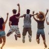 Jóvenes cristianos saltando de alegría durante un encuentro espiritual al aire libre
