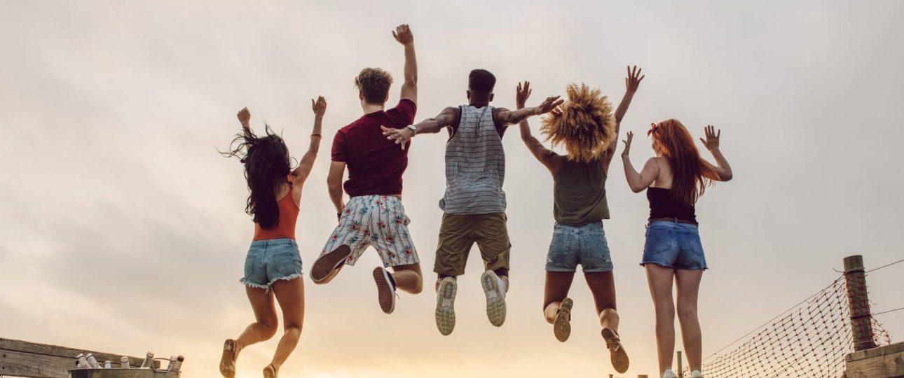 Jóvenes cristianos saltando de alegría durante un encuentro espiritual al aire libre