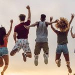 Jóvenes cristianos saltando de alegría durante un encuentro espiritual al aire libre