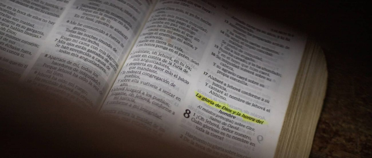 Biblia abierta con un versículo resaltado en amarillo.