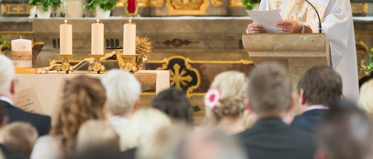 Sacerdote sosteniendo el cáliz y el micrófono durante una celebración eucarística al aire libre.