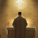 Sacerdote sosteniendo el cáliz durante la consagración en la misa católica.