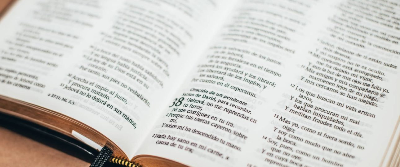 Página iluminada de la Biblia con el capítulo 12 de Romanos.