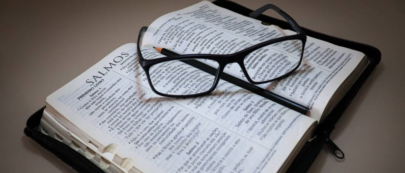 Salmo 91: Significado, Promesas y Cómo Orarlo en Tiempos Difíciles 6 Biblia abierta con gafas sobre ella, reflejando la meditación consciente del Salmo 91.